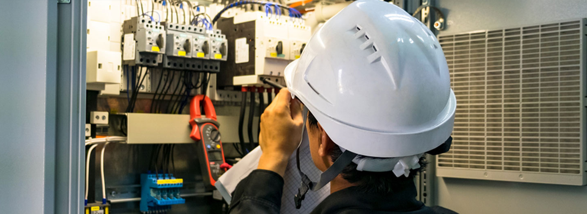 Electrician inspecting circuit breakers inside an electrical control panel for Anchor Electric in Sarasota.