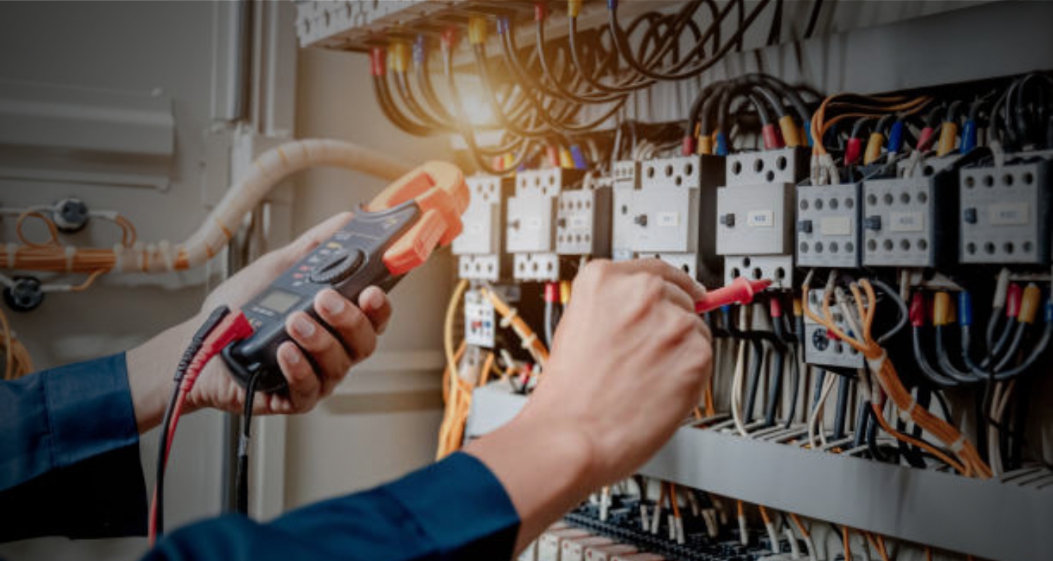 Anchor Electric technician in Sarasota using a digital clamp meter to test commercial control panels