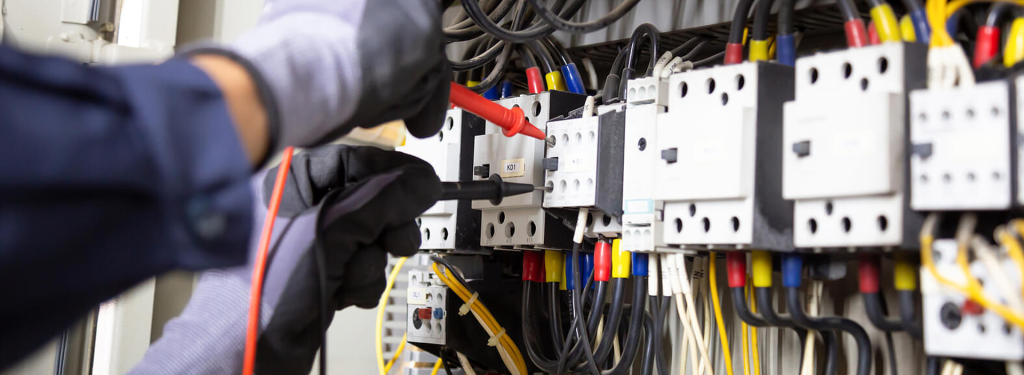 Electrician testing electrical equipment during a panel diagnosis