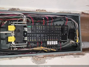 Licensed electrician installing a modern electrical breaker panel for a Sarasota Florida home.