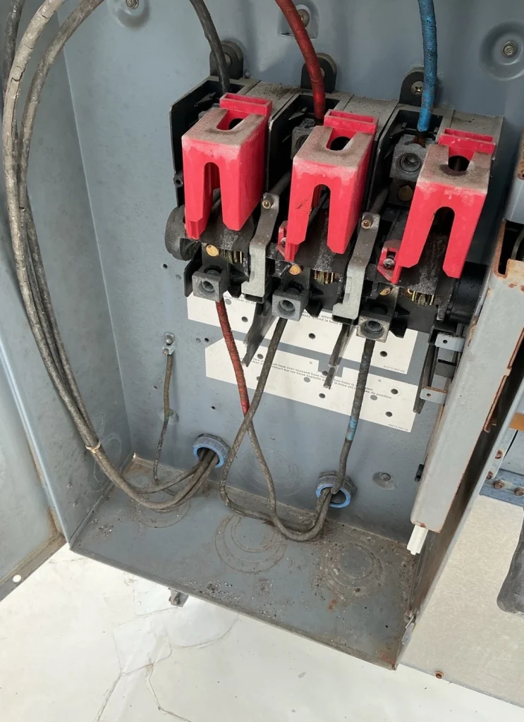 Older electrical service equipment showing worn components and wiring